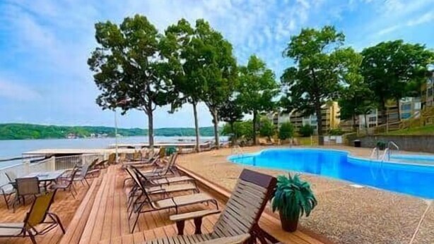 A wooden deck with lounge chairs and a pool. - Beautiful Views at Bay Point Condominiums! (Osage Township)