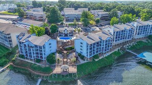Ein mehrstöckiges Hotel mit Swimmingpool, Anlegesteg und Blick auf den Fluss.