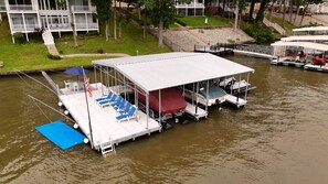 A floating dock with a covered seating area, a flag, and a small flagpole. - Your Perfect LOZ Getaway! (Pawhuska Township)