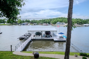 A dock with boats, a covered area, and a flag. - Your Perfect LOZ Getaway! (Pawhuska Township)