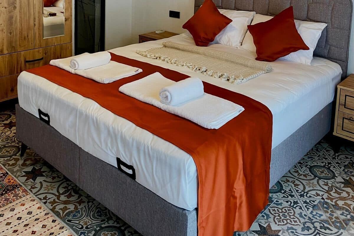 Un dormitorio con cama, armario de madera y espejo.