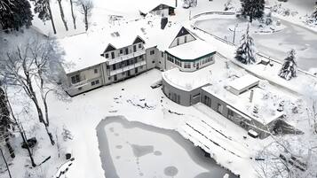 A snow-covered landscape with a large building complex, including multiple structures and a central courtyard.