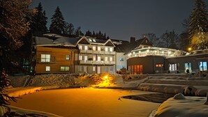 A snow-covered outdoor area with a pool, buildings with balconies, and snow-covered trees. - Apartment in A Hotel 'Pensionszimmer 24 Qm Mit Balkon (copy)' with Shared Garden, Balcony and Wi-Fi (Suhl)