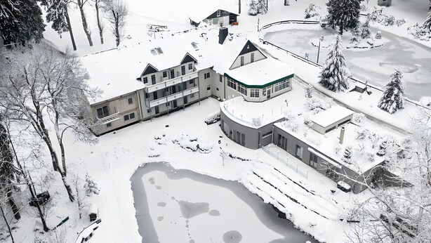 A snow-covered landscape with a large building complex, including multiple structures and a pond. - Apartment in A Hotel 'Pensionszimmer 24 Qm Mit Balkon (copy)' with Shared Garden, Balcony and Wi-Fi (Suhl)