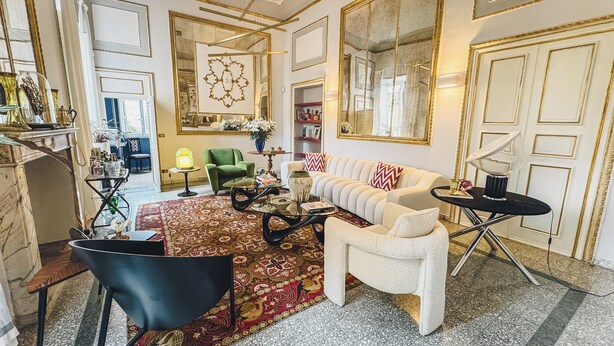 Un salón amplio con un sofá, sillones, una mesa de centro y una chimenea.