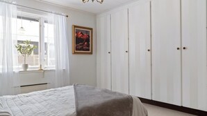 A bedroom with a bed, a window with curtains, a potted plant, and a framed picture on the wall. - Central house with AC near the beach (Piteå)