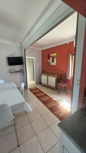 A room with a dining table, chairs, a TV, a cabinet, and a red wall. - Comfortable getaway near Braga • 2 bedrooms - Up to 5 people (Crespos)