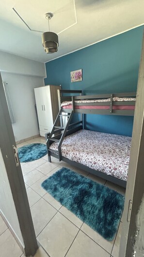 A room with a bunk bed, a wardrobe, a radiator, and a blue wall. - Comfortable getaway near Braga • 2 bedrooms - Up to 5 people (Crespos)