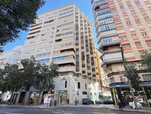 A multi-story building with balconies, a ground-level entrance, and a clear sky. - Your Peaceful Luxury Stay in the Heart of Madrid (Madrid)