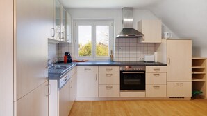 Una cocina con estufa, horno y ventana con vistas.