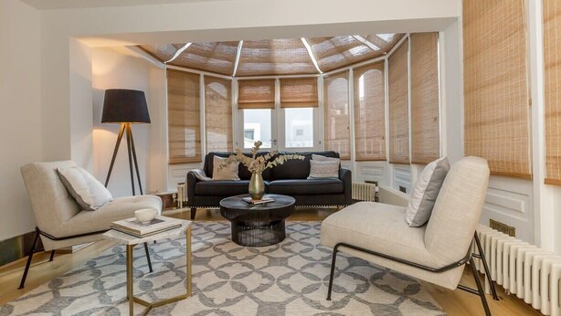 Una sala moderna con un sofá, dos sillones, una mesita de centro y una lámpara de pie.