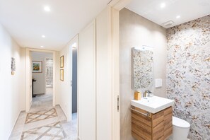 A modern bathroom with a wooden vanity, a mirror, and a toilet. - Alberico II Apartment (Rome)