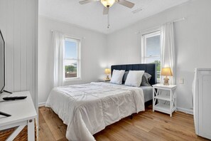 A bedroom with a bed, bedside tables, a ceiling fan, and a window with blinds. - Unit A/B/C Walk to Beach/Intercoastal/Fishing Pier (Holly Ridge)
