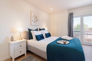 A bedroom with a bed, nightstand, and a window with a view. - Modern & Spacious Flat with Balcony by HostWise (Porto)