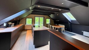 A modern loft-style kitchen with a central island, built-in appliances, and large windows. - Vermillion Autumn Suites (Aalborg)