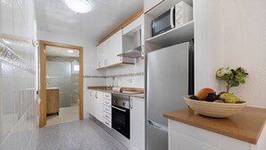 A modern kitchen with stainless steel appliances, a wooden countertop, and a bowl of fruit. - Apartment 'Cristina' with Private Terrace, Wi-Fi, and Air Conditioning (Deltebre)