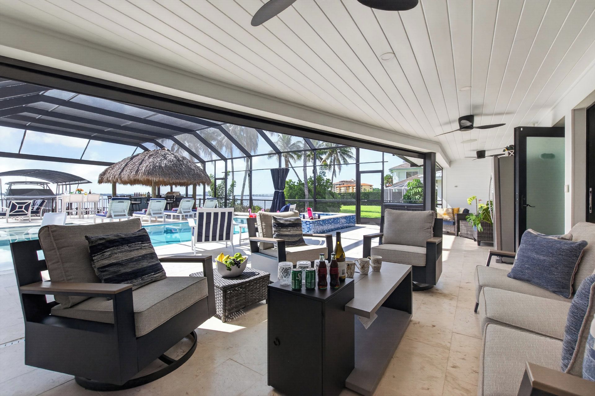 Un área de estar moderna al aire libre con piscina, asientos y vistas al océano.