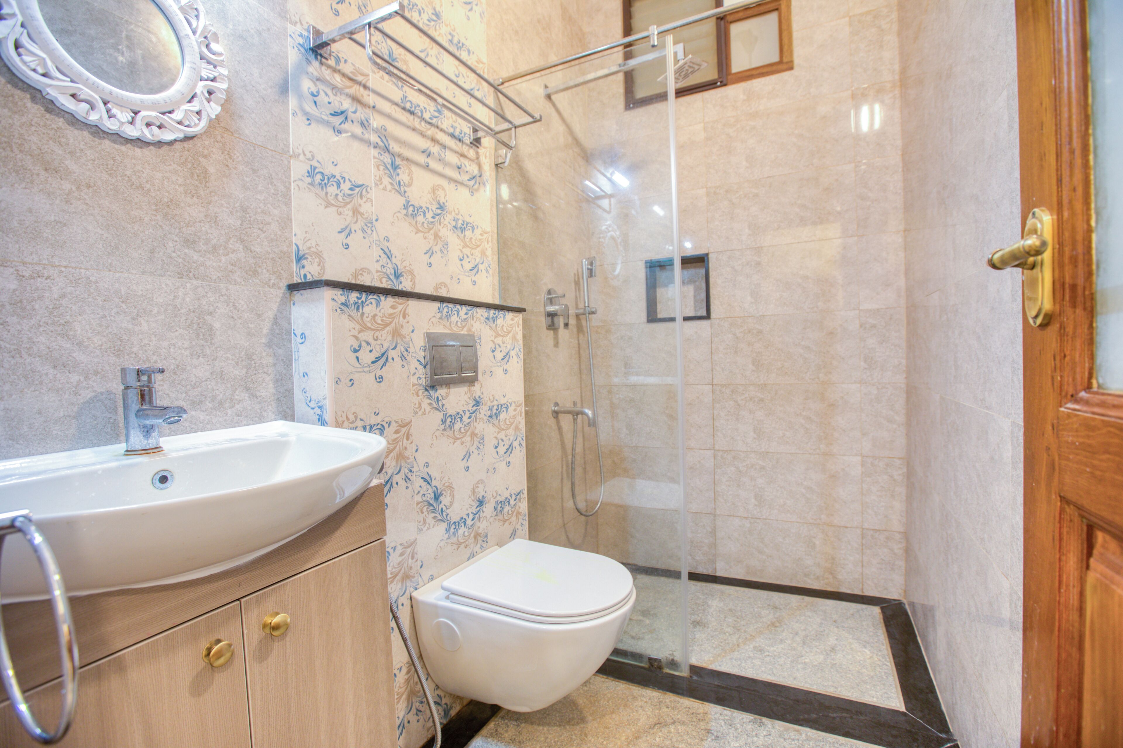 Une salle de bain équipée d’un lavabo, de toilettes, d’une douche et d’un miroir.