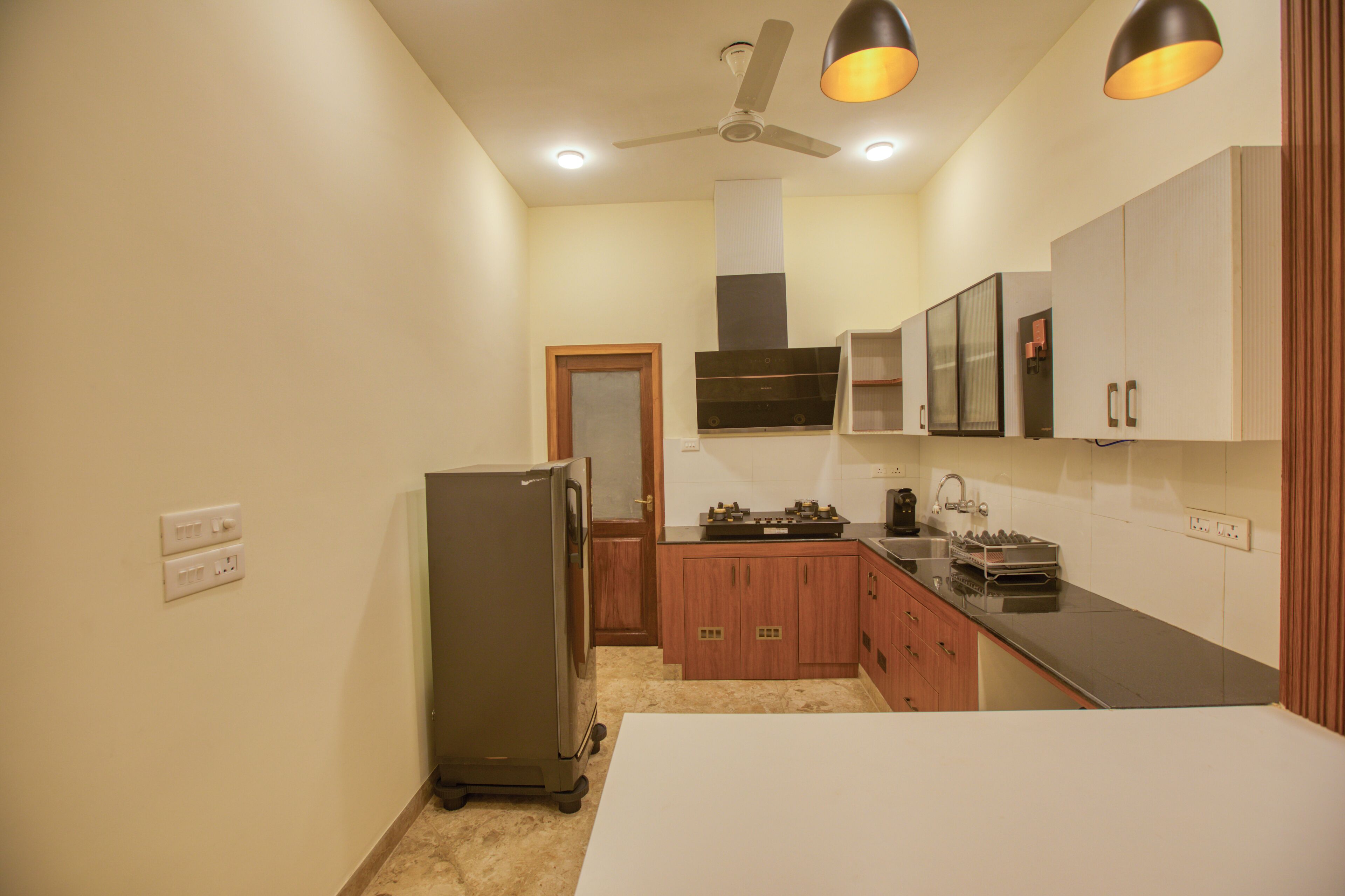 A compact kitchen with a refrigerator, stove, microwave, and cabinets.