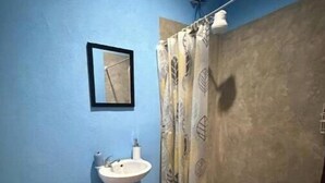 Un baño pequeño con inodoro, lavamanos y cortina de ducha.