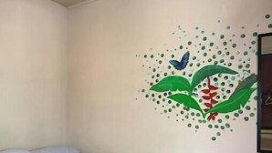 Una habitación con una cama, un mural en la pared y una ventana.