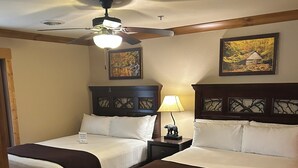 A hotel room with two beds, a ceiling fan, a nightstand with a lamp, and a painting on the wall. - Great Smokey Mountain Resort, condo Nestled between Gatlinburg & Pigeon Forge TN (Gatlinburg)