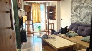 A living room with a sofa, a coffee table, and a door leading to another room.