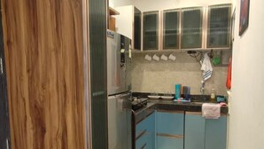 A compact kitchen with a stove, cabinets, and a sink.