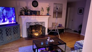 A living room with a fireplace, a television, and a coffee table with various items. - 3-bedroom houseone of the safest areas in Long Beach - Bixby centrally located (Long Beach)