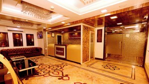 A hotel reception area with a sofa, reception desk, and a patterned floor.