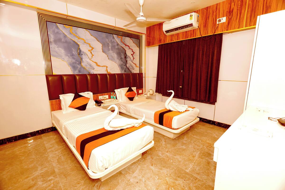A hotel room with two beds, a marble floor, a ceiling fan, an air conditioning unit, and a large abstract painting on the wall.