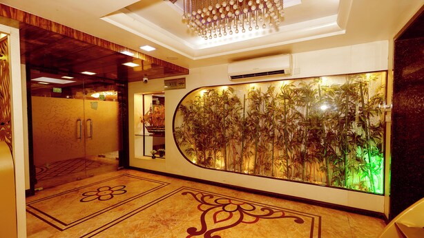 A hotel lobby with a large aquarium, a wooden ceiling, and a patterned floor.