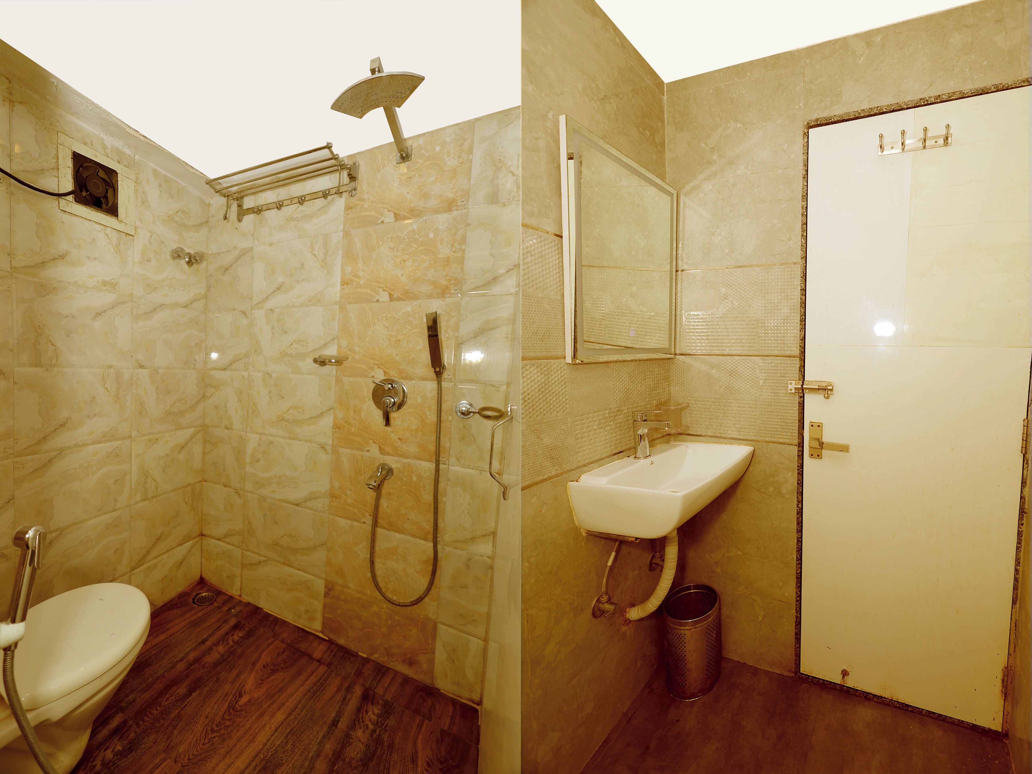 Un baño con ducha, inodoro, lavabo y una puerta con espejo.