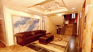 A modern living room with a sectional sofa, a coffee table, and a large abstract wall art.