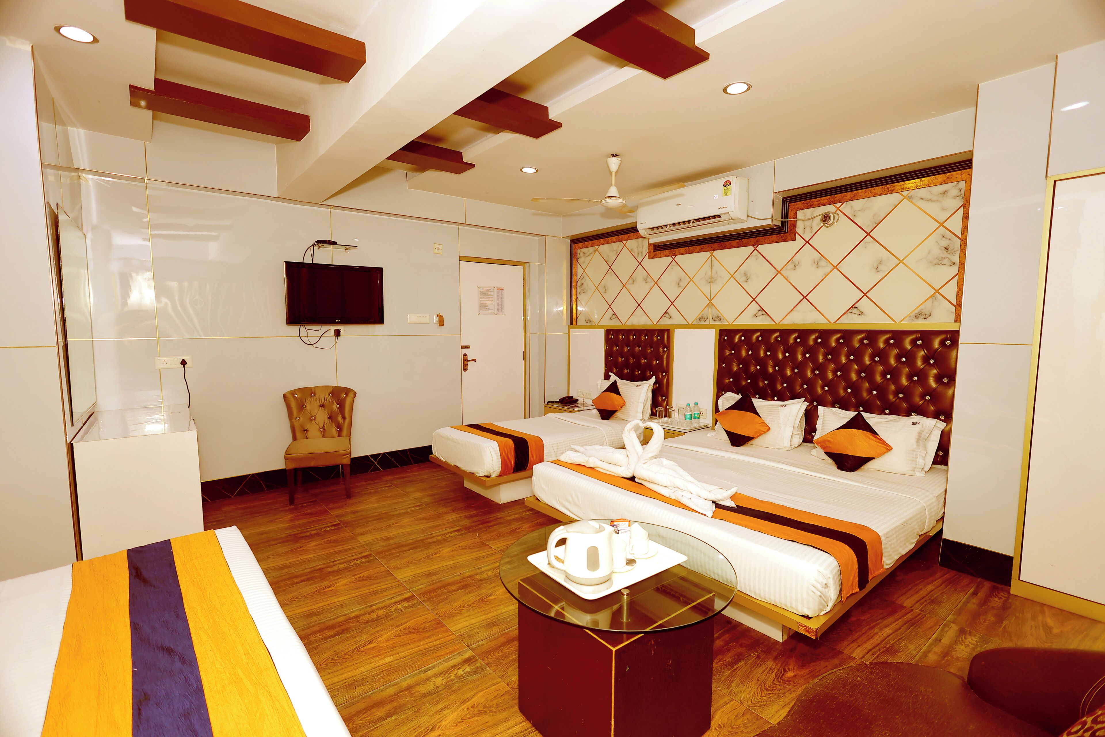 A hotel room with a bed, a television, a seating area, and a coffee table.