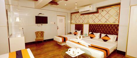 A hotel room with a bed, a television, a seating area, and a coffee table.