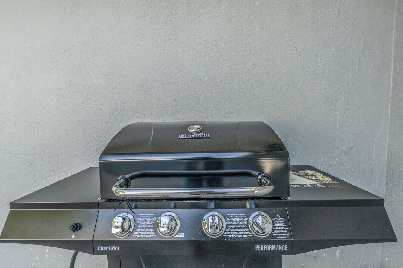 Un barbecue à gaz Char-Broil doté d’un écran numérique, d’un bouton de commande et d’une poignée en acier inoxydable.