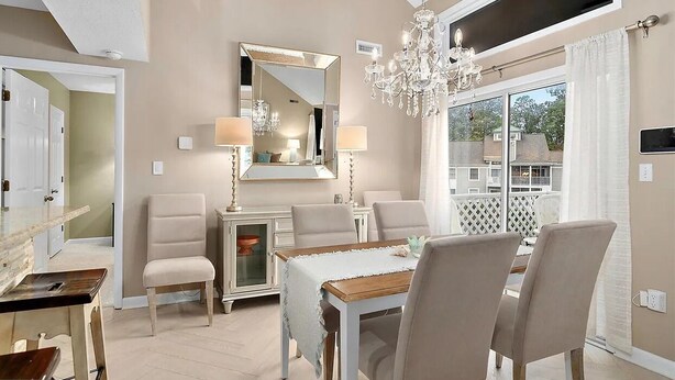 Un comedor con candelabro, un espejo grande y vistas al exterior.
