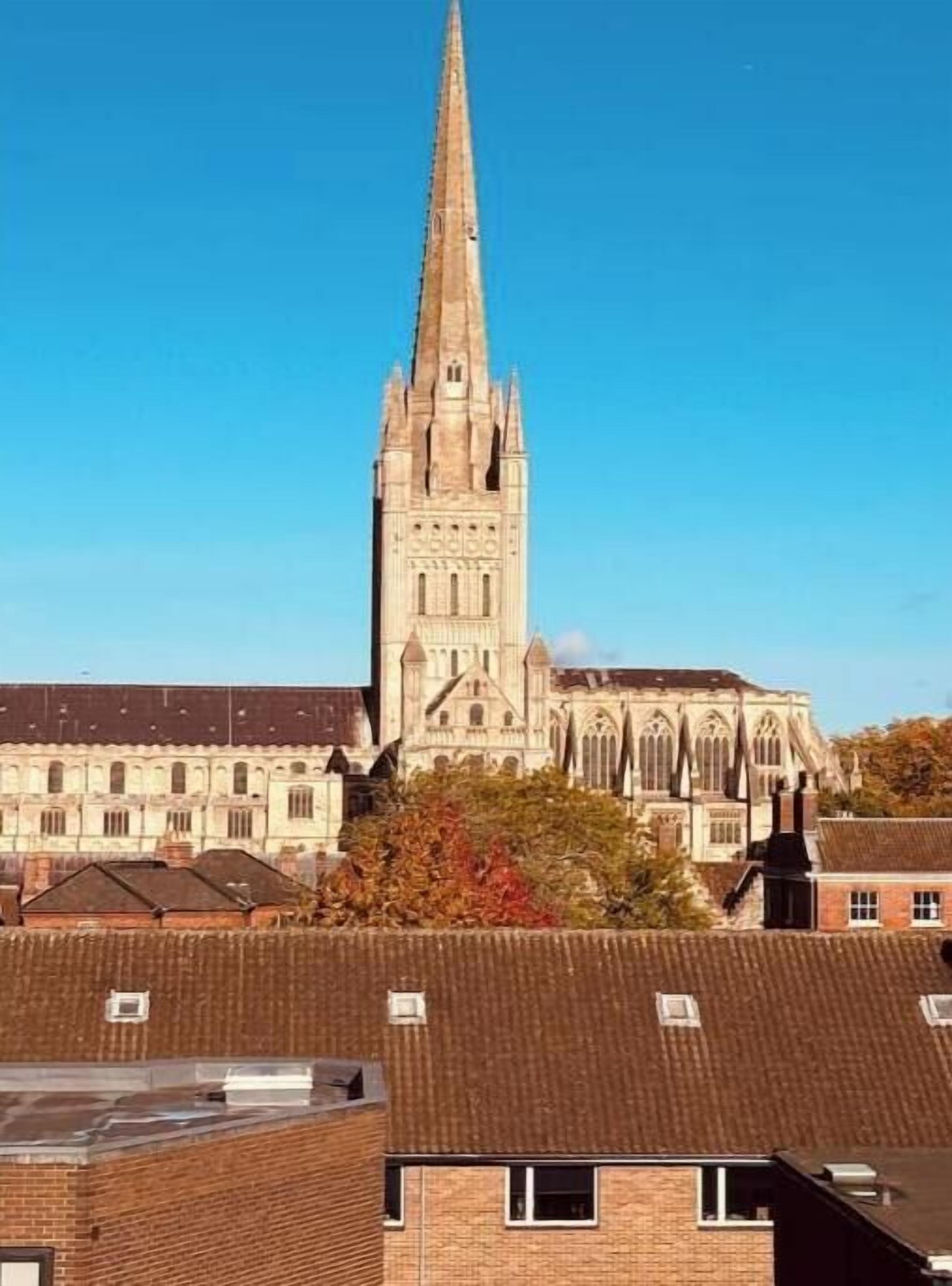 Une église historique, reconnaissable à son clocher imposant, entourée d’immeubles d’habitation.