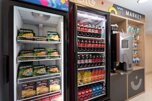 A vending machine with snacks and drinks, a microwave, and a coffee machine. - Howard Johnson | King | Free Shuttle to Theme Parks & Pool Fun with the Kids (Kissimmee)
