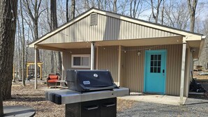 A small outdoor structure with a grill and a door. - Charming Pocono Bungalow with Firepit, Grill, Outdoor seating, Walk to Lake (Pocono Lake)