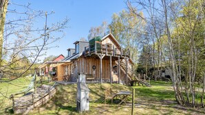 Eine Holzhütte mit Balkon, Hängematte und einer Holzterrasse.