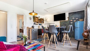 Ein modernes Wohnzimmer mit Küche, Essbereich und Sitzgelegenheiten.