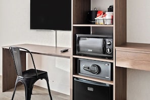 A kitchenette with a microwave, coffee maker, and a Black & Decker appliance on a wooden shelf. - King | Howard Johnson | Near Disney Excitement with Free Shuttle | Pool Fun (Kissimmee)