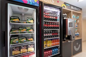 A vending machine with snacks and drinks, a microwave, and a coffee machine. - King | Howard Johnson | Near Disney Excitement with Free Shuttle | Pool Fun (Kissimmee)