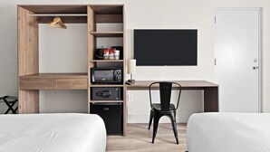 A modern hotel room with a wooden desk, a black chair, a flat-screen TV, a wardrobe, and two beds. - 2 Queen | Howard Johnson | Room for Whole Crew! | Near Disney w/ Free Shuttle (Kissimmee)