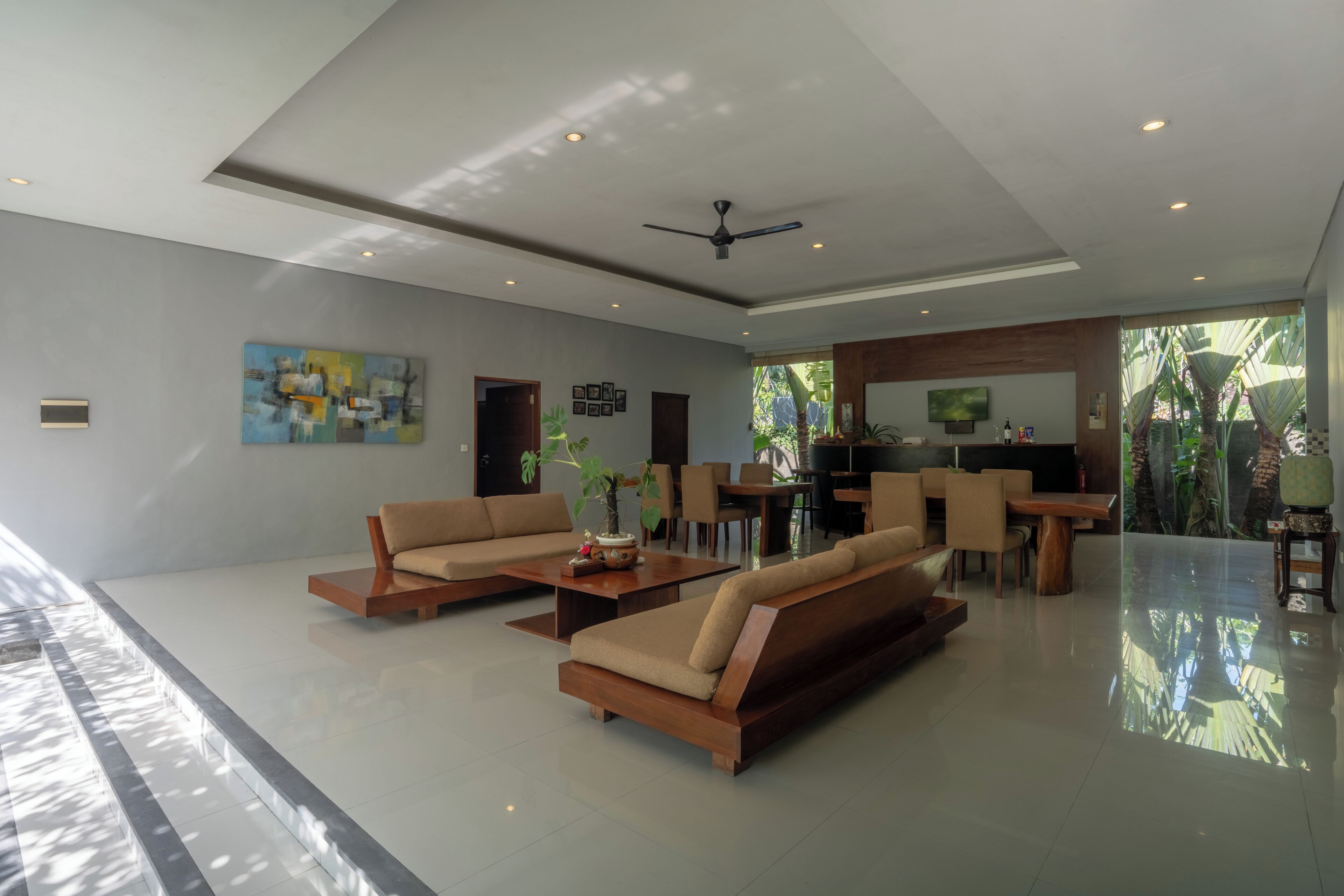A spacious living area with sofas, a coffee table, and a dining area.
