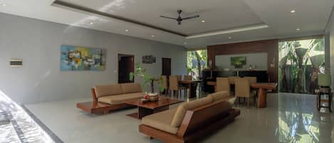 A spacious living area with sofas, a coffee table, and a dining area.