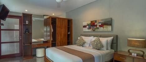 A bedroom with a bed, wooden wardrobe, bedside table, and a ceiling fan.