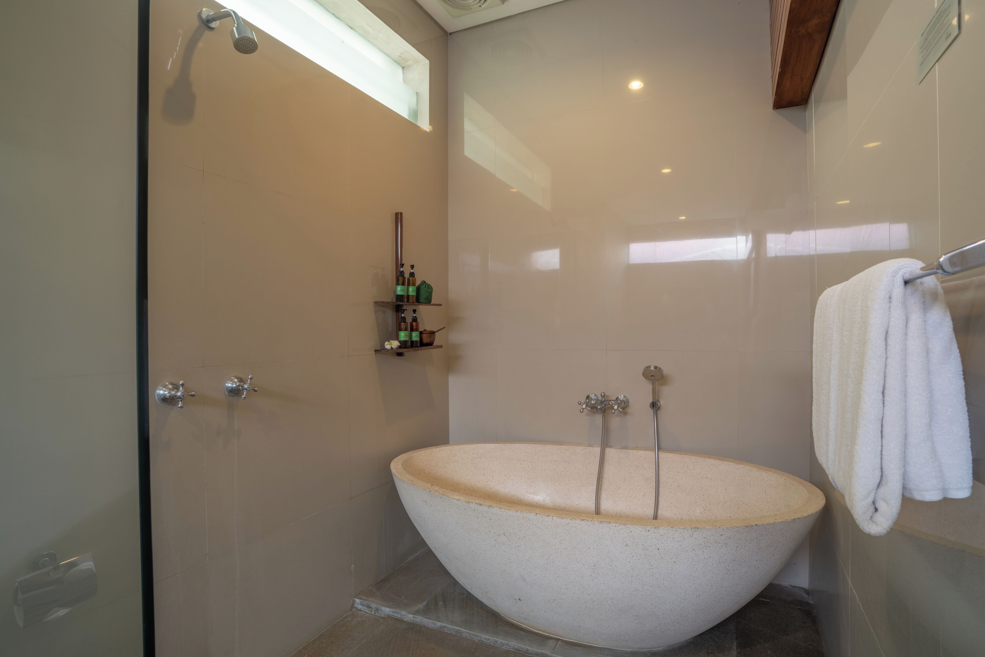 A bathroom with a freestanding bathtub, a glass shower enclosure, and a towel rack.